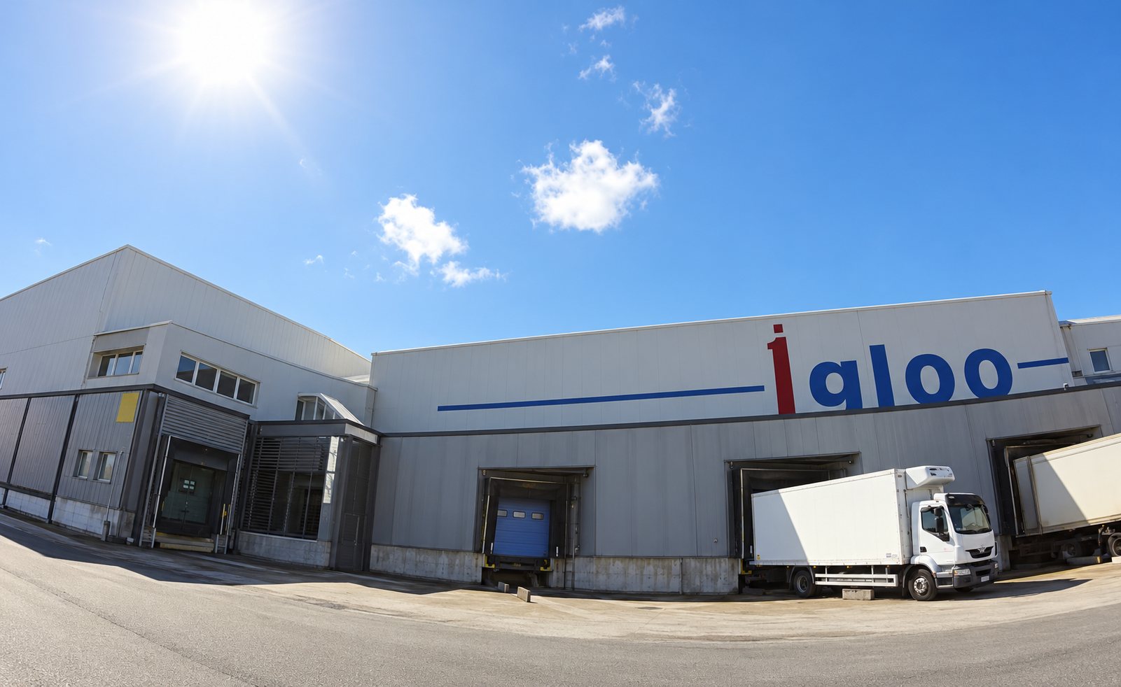 Façade d’un entrepôt portant l’enseigne Igloo, avec un camion blanc garé devant les quais de chargement